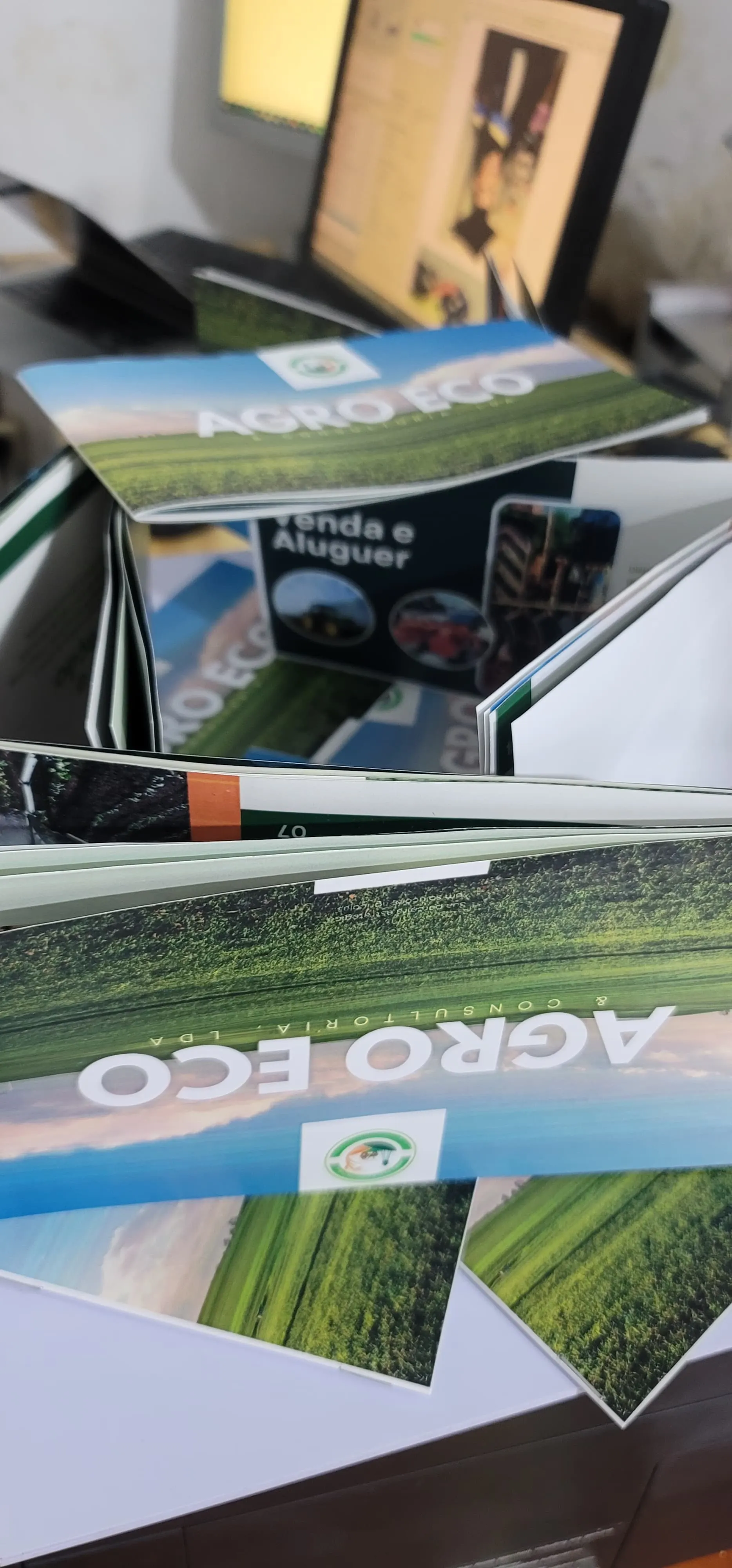 Folheto institucional impresso para a Agro Eco & Consultoria, Lda, aberto sobre uma secretária